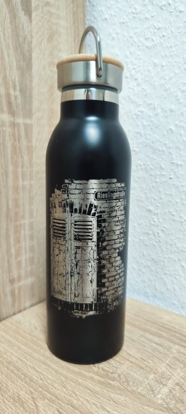 Schwarze Edelstahlflasche mit Bambusdeckel und silberner Gravur einer alten Tür in einer Backsteinmauer mit Schild „Rieslingstraße“.